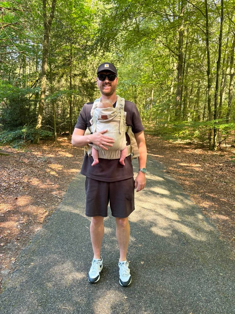 Jan-Willem, de maker van BabyTracker, met zijn zoon Sem in de draagzak op een bospad